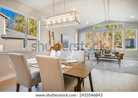 Dining room interior with table and chairs table settings staged with dinnerware flowers large windows bright and spacious home interior photography