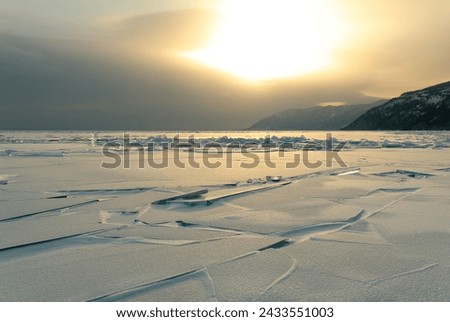 The burst coastal ice on Lake Baikal. A variety of forms of crushed ice. Sunset. Horizontal.