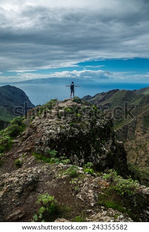 Man standing on the hill against background of the beautiful mountain landscape