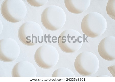 Close up of geometric concrete white background with many convex round sameless elements with copy space. Design elements with black and white pattern like moon. Beautiful background for your design
