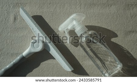 Cleaning kit. squeegee to wash a window, brush and spray bottle on a gray background Royalty-Free Stock Photo #2433585791