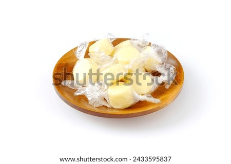 Candy cheese, cheese made similar to candy on wooden plate isolated and white background. Royalty-Free Stock Photo #2433595837