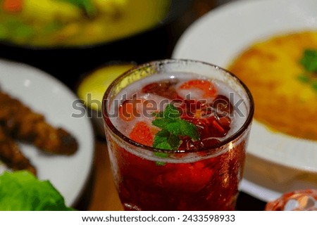Fresh drink on the table. Strawberry mocktail with mint leaves as garnish. Minuman dingin