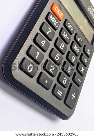 A sleek black calculator in close-up, set against a pure white background, embodies a minimalist yet functional aesthetic