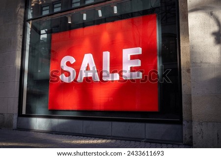 Eye-Catching Offer: Vibrant Red Sale Sign in a Storefront Window, Attracting Shoppers