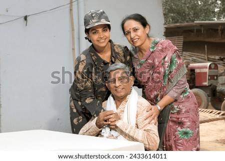 Indian happy female soldier hugging with rural parents in village.