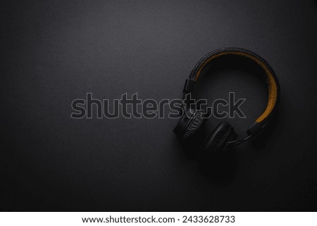 Retro style wireless over-ear headphones on dark gray background Royalty-Free Stock Photo #2433628733