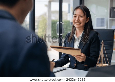 Lawyer shaking hands with client after discussing final contract agreement.
