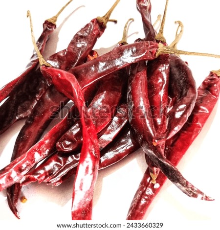 
A pile of dried curly chili peppers, white background"