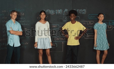 Multicultural people pose at camera while standing with confident. Diverse high school children crossing arm or posing to camera at blackboard with prompt or coding plan at STEM class. Edification.