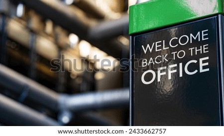 Welcome back to the office on a sign in front of an Industrial building	