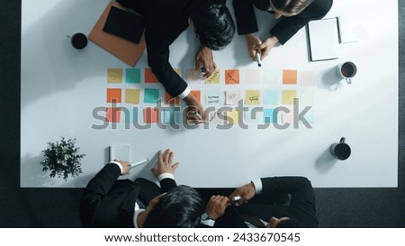 Top view of professional business team planning marketing strategy. Group of diverse business people writing and sharing creative idea. Smart project manager walking and standing at table. Directorate