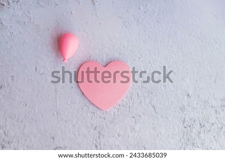 Pink heart sticky note on gray textured  background with copy space 