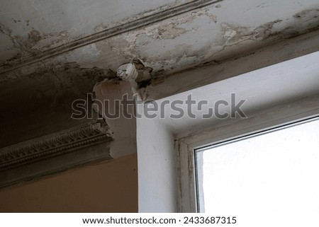 Peeling paint on an interior ceiling a result of water damage caused by a leaking pipe a result of substandard plumbing completed by an unqualified plumber. A common house insurance claim Royalty-Free Stock Photo #2433687315