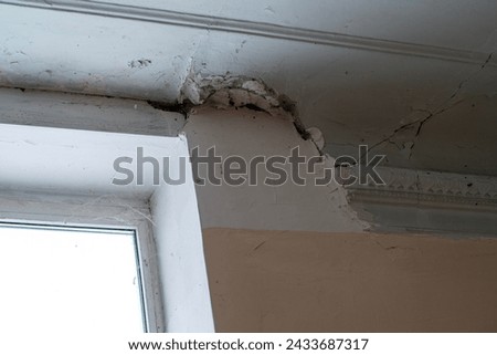 Peeling paint on an interior ceiling a result of water damage caused by a leaking pipe a result of substandard plumbing completed by an unqualified plumber. A common house insurance claim Royalty-Free Stock Photo #2433687317