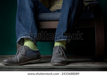 Legs of a business man in elegant clothes, yellow silk socks and shoes