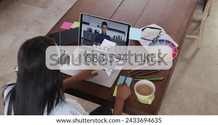 Thumb icon and increasing likes against woman having a image call on laptop at office. social media networking and business concept