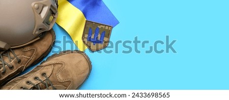 Badge with trident, military boots, tactical helmet and flag of Ukraine on blue background with space for text