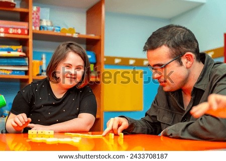 People with special needs playing board skill games in a day center Royalty-Free Stock Photo #2433708187