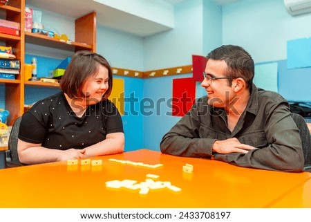 Woman with down syndrome and disabled man playing board games in a day center Royalty-Free Stock Photo #2433708197