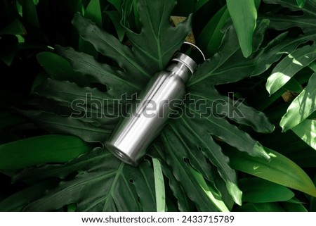 Drinking aluminum bottle mockup template, real photo, set amidst the lush backdrop of tropical nature environment. Blank isolated object to place your design. 