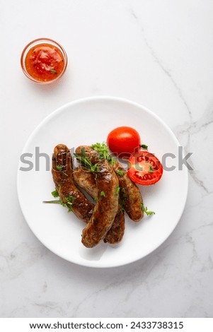 Grilled sausages  and sauces on light surface bbq food top view Royalty-Free Stock Photo #2433738315