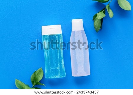 Face cleaning. Organic cosmetics. Mycelial water, lotion for skin care and plant on blue background flat lay space for text Royalty-Free Stock Photo #2433743437