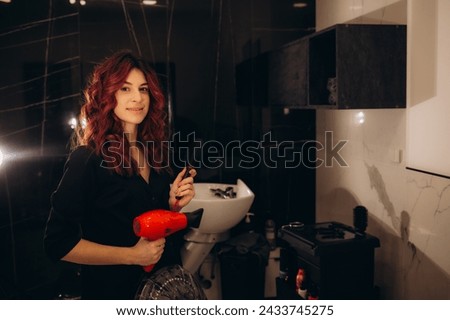 Portrait of happy hairdresser with professional scissors in beauty salon. High quality photo