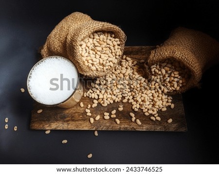 Yellow food soybeans in two gunni sacks as well as a cup of soybean water
