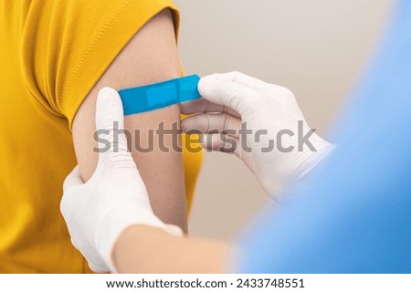 Vaccination coronavirus, hand of nurse apply plaster, bandage after doctor giving vaccine, injection dose on arm patient, immunization disease prevention against flu pandemic influenza, health care.