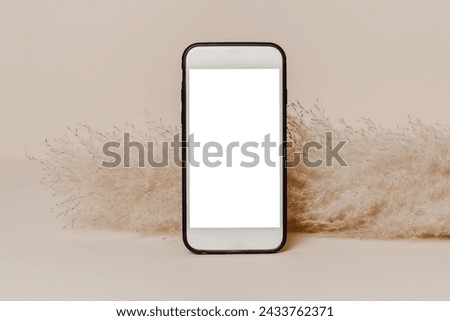 Empty mobile phone mockup with white screen and pampas grass at the background. Smartphone template background for design and branding, greeting and invitation, social media, website promotion