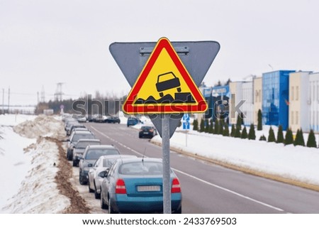 Soft verges. Warning sign, traffic sign and cars parked in row along dangerous snowy roadside on background. Soft verge road sign, car parked with traffic violation. Dangerous parking on soft roadside Royalty-Free Stock Photo #2433769503