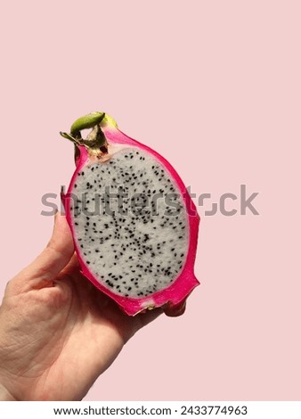 exotic dragon fruit, eating cut in half in hand, on a pink background, poset, no background, wallpaper