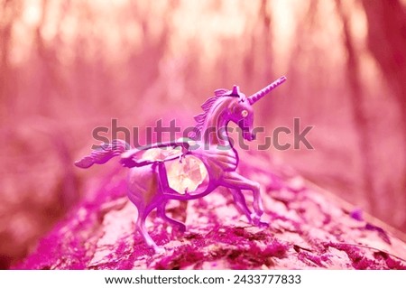 A unicorn figurine decorated with decorative glass on a purple background.
