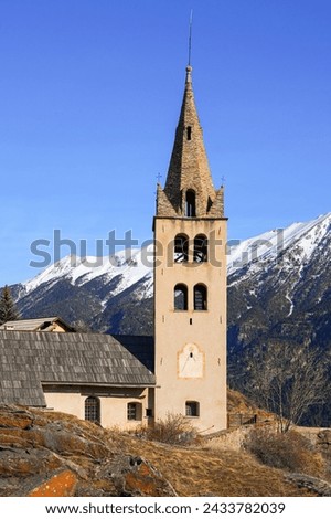 Bell tower of the church of Saint Peter in Puy-Saint-Pierre, a hillside Alpine village located above Briançon in the Hautes Alpes department of the French Alps, France Royalty-Free Stock Photo #2433782039