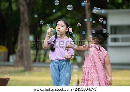 Girls in the park with blowing air bubble, Surrounded by greenery and nature