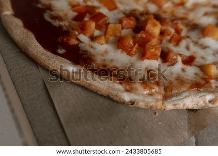 Kyiv, Ukraine. On March 2, 2024, a freshly made pizza delivered for breakfast from a pizzeria lies on a table in a cardboard box. pizza with cheese and red tomatoes on thin dough. tasty and hot