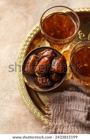 Dates 'Kurma' and Hot tea. Traditional Ramadan Kareem concept snack for Iftar or Suhoor meal on warm background. Royalty-Free Stock Photo #2433815199