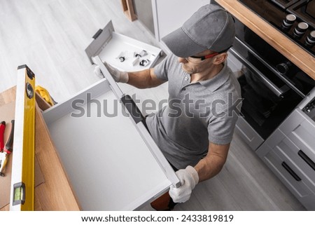 Professional Caucasian Cabinetmaker Fitting Kitchen Furniture Drawer Royalty-Free Stock Photo #2433819819