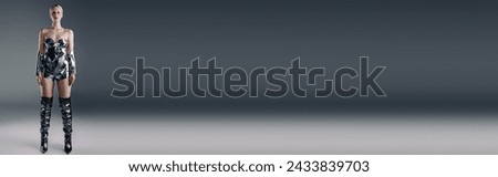 futuristic peculiar woman in metallic attire looking straight at camera on gray backdrop, banner Royalty-Free Stock Photo #2433839703