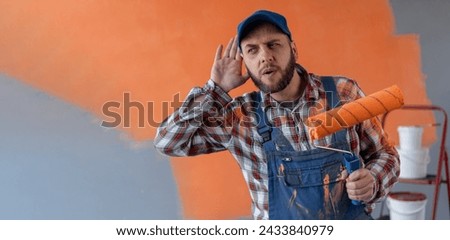 Painter man holding roller, with hand over ear listening and hearing to rumor or gossip. Deafness concept. Banner. Copy space