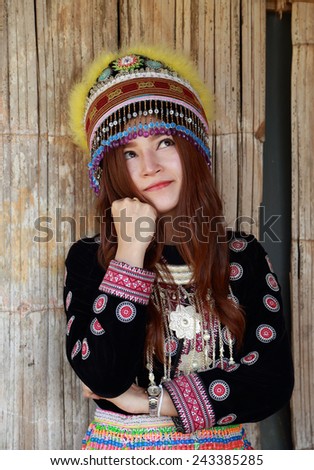 Traditionally dressed Mhong hill tribe woman thinking in the wooden cottage