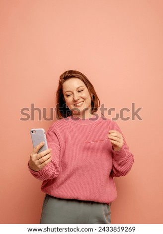 tehnology and modern senior people concept: Portrait of surprised woman talking by mobile phone over pink background