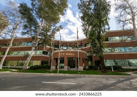 City Hall three story modern brick building entrance, green lawn, clouds. Horizontal wide street view Royalty-Free Stock Photo #2433866225