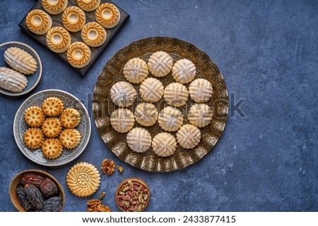Arabic sweets. Traditional eid semolina maamoul or mamoul cookies with dates , walnuts and pistachio nuts . Top view Royalty-Free Stock Photo #2433877415