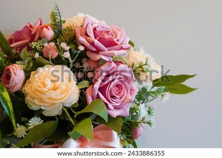 top view pinks and yellow rose flowers bouquet on white cement wall background, nature, template, decor, copy space                                                         