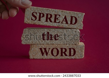 Spread the word symbol. Brick blocks with text Spread the word. Beautiful red background, copy space. Businessman hand. Business concept.