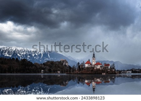 Bled, Slovenia - Beautiful view of Lake Bled (Blejsko Jezero) with reflecting Pilgrimage Church of the Assumption of Maria on Bled Island, Bled Castle and Julian Alps at background at winter time