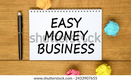 Easy money business symbol. Concept words Easy money business on beautiful white note. Beautiful wooden background. Black pen. Colored paper. Easy money business concept. Copy space.