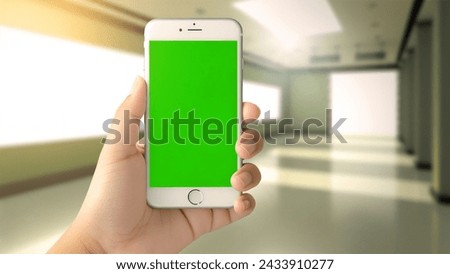 Green screen smartphone mockup held in hand, indoor blurred background, customizable mobile app interface concept Royalty-Free Stock Photo #2433910277